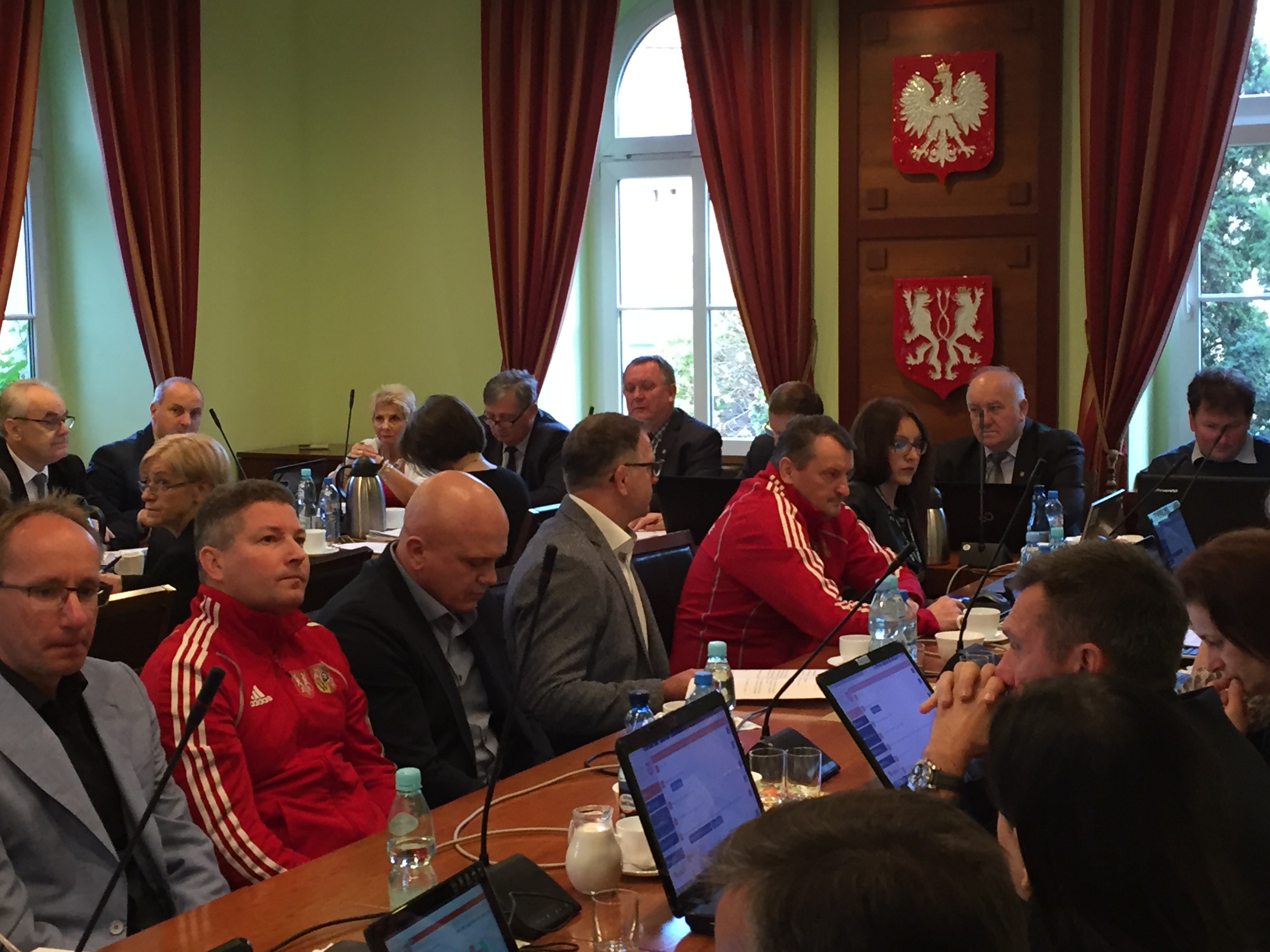 zdjęcie przedstawia salę obrad w czasie sesji RM, czterech sportowców reprezentujących zapasy