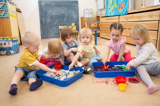 zdjęcie przedstawia sześcioro bawiących się na podłodze dzieci