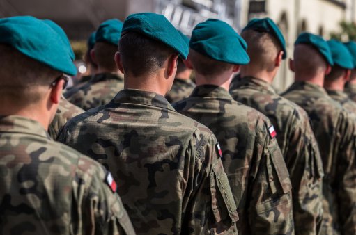 zdjęcie przedstawia stojących tyłem żołnierzy ubranych w mundury moro i berety