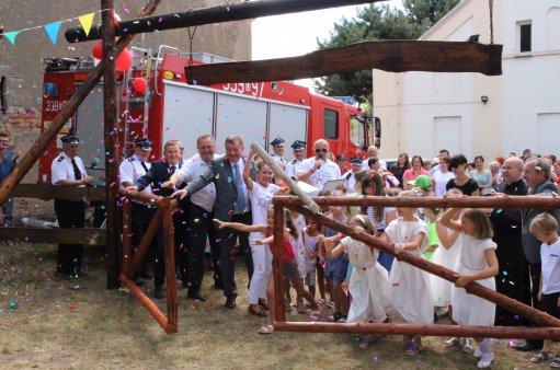 zdjęcie przedstawia grupę ludzi otwierających drewniana bramę