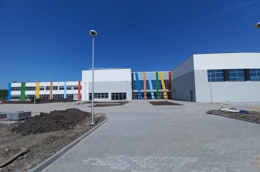 Widok na wejście główne do części szkolnej ZSP w Krzeptowie  z przestrzenią parkingową 